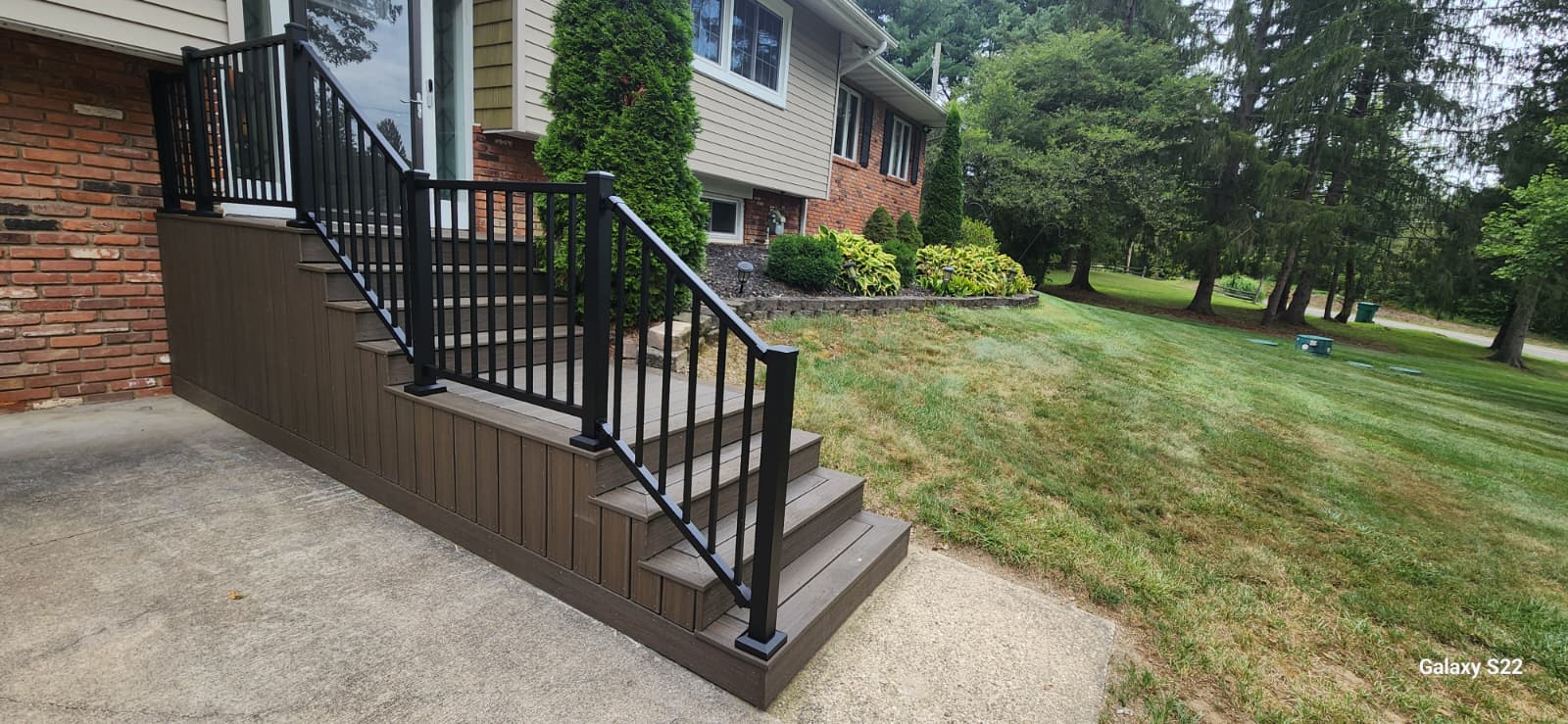 Finished custom exterior stairs and black railings built for a residential home